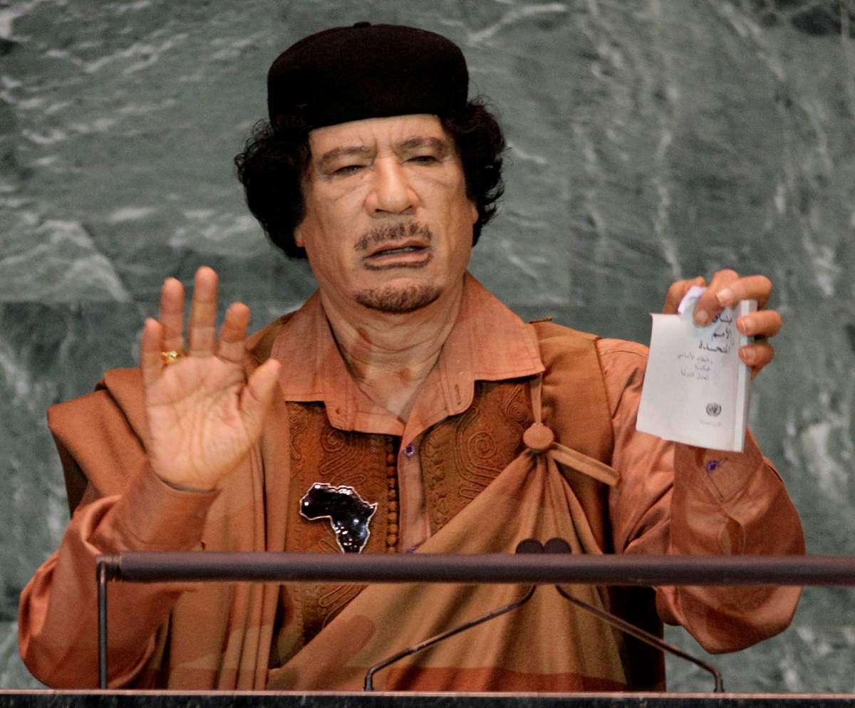 In this Sept. 23, 2009 photo, Libyan leader Moammar Gadhafi shows a torn copy of the UN Charter during his address to the 64th session of the United Nations General Assembly.