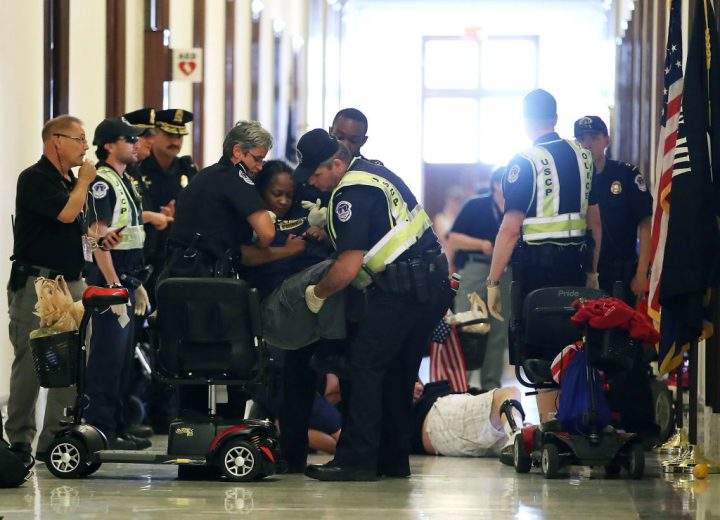 U.S. Capitol Police remove protesters from in front of the office of Senate Majority Leader Mitch McConnell.