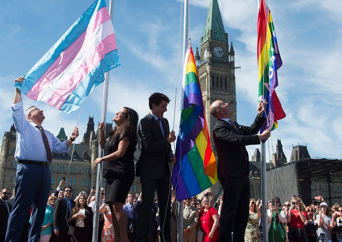 Public Safety and Emergency Preparedness Minister Ralph Goodale(left), Minister of Justice and Attorney General of Canada Jody Wilson-Raybould, Canadian Prime Minister Justin Trudeau and Liberal MP Randy Boissonnault raise the pride and transgender flags on Parliament Hill in Ottawa, Wednesday June 14, 2017. 