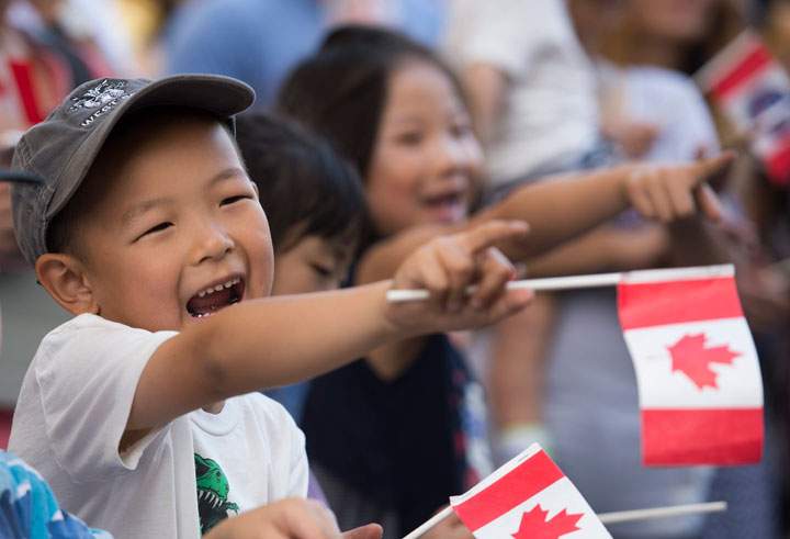 A young boy smiles as he watches the annual Canada Day parade