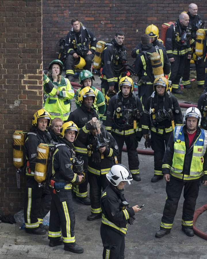 Firefighters look up at a London apartment fire