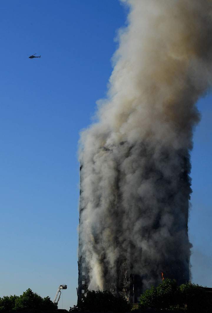 A helicopter is seen as flames and smoke billow
