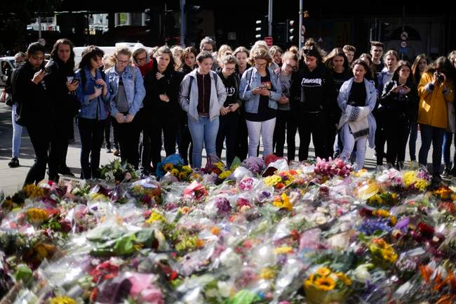 People look at floral tributes on London Bridge, Wednesday, June 7, 2017, to commemorate the victims in Saturday's attack.