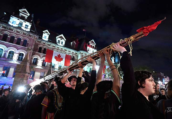 People hold a teepee, intended to be erected on Parliament Hill as part of a four-day Canada Day protest during a demonstration in Ottawa on Thursday, June 29, 2017.