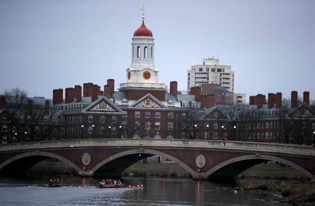 FILE - In this March 7, 2017 file photo, rowers paddle down the Charles River near the campus of Harvard University in Cambridge, Mass.
