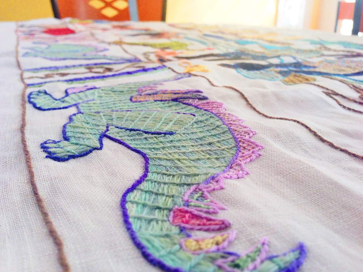 One of 600 dinosaurs stitched into the linen