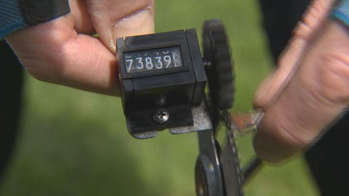 Laurie Penton demonstrates the device used to help measure the Manitoba Marathon route.