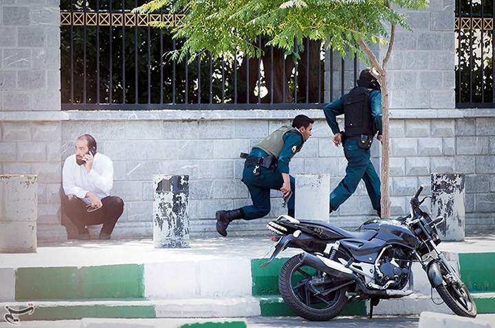 Members of Iranian forces run during an attack on parliament in central Tehran, June 7, 2017.