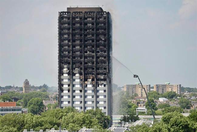 Firefighters spray water onto the 24-storey apartment block in west London.