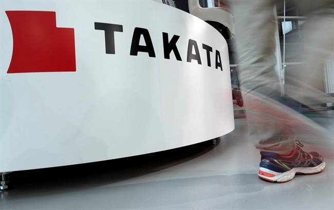 In this May 10, 2017 photo, a visitor walks past the logo of Takata Corp. at a Toyota showroom in Tokyo. 