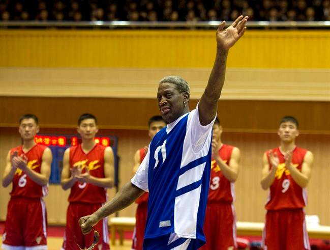 In this Jan. 8, 2014, file photo, Dennis Rodman waves to North Korean leader Kim Jong Un, seated above in the stands, after singing Happy Birthday to Kim before an exhibition basketball game with U.S. and North Korean players at an indoor stadium in Pyongyang, North Korea.
