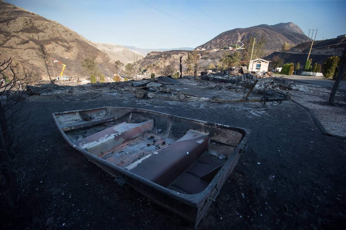 The remains of a boat are seen on a property at a trailer park almost completely destroyed by wildfire in Boston Flats, B.C., on Sunday July 9, 2017. B.C. government officials now estimate that 7,000 people have been evacuated from their homes due to wildfires burning in the province. THE CANADIAN PRESS/Darryl Dyck