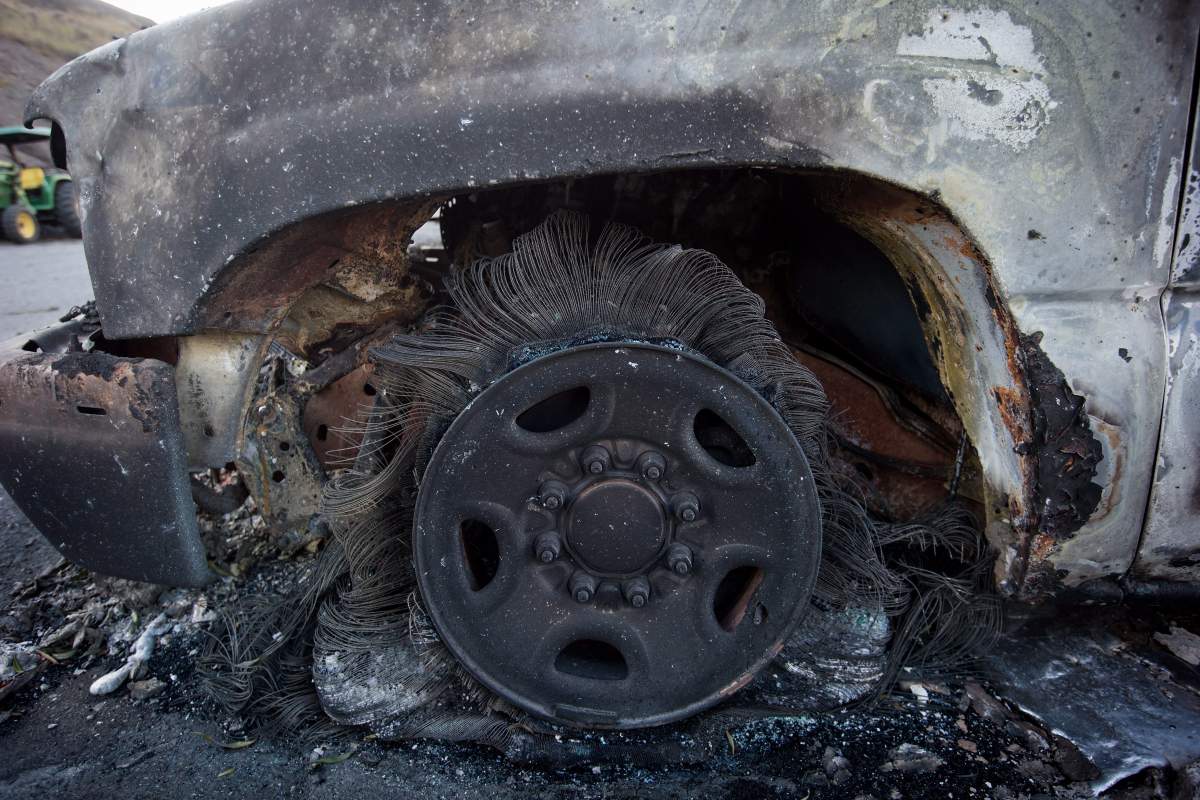A burnt wheel on a vehicle is seen at a trailer park almost completely destroyed by wildfire in Boston Flats, B.C., on Sunday July 9, 2017. B.C. government officials now estimate that 7,000 people have been evacuated from their homes due to wildfires burning in the province. THE CANADIAN PRESS/Darryl Dyck