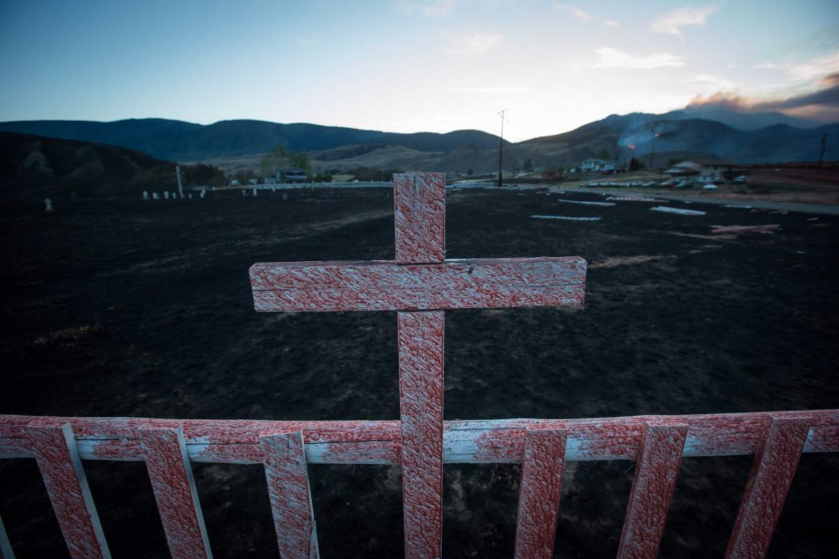 Fire retardant coats a cross at a cemetery on the Ashcroft First Nation where numerous homes were destroyed by wildfire, near Ashcroft, B.C., late Sunday July 9, 2017. THE CANADIAN PRESS/Darryl Dyck