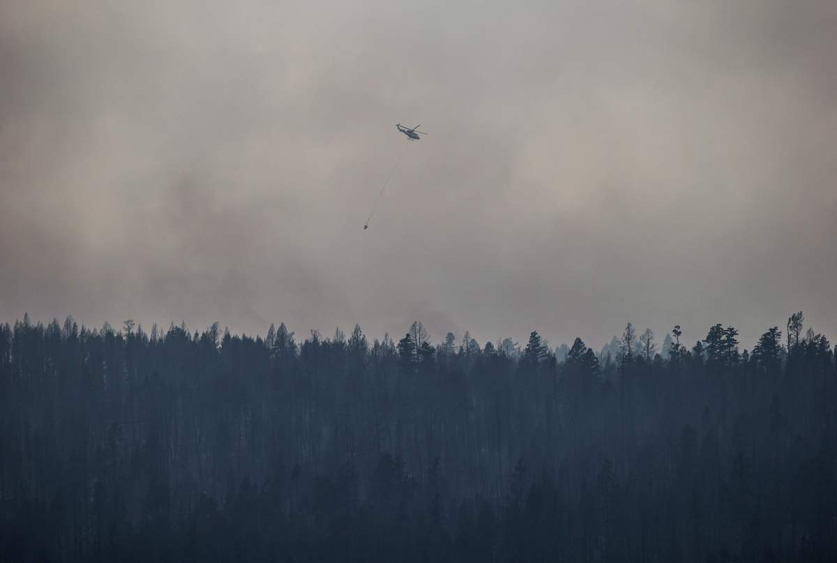 A helicopter is used to battle a wildfire burning on the top of a mountain near Ashcroft, B.C., on Monday, July 10, 2017. More than 200 wildfires are burning in the province and an estimated 14,000 people have been evacuated from their homes. THE CANADIAN PRESS/Darryl Dyck