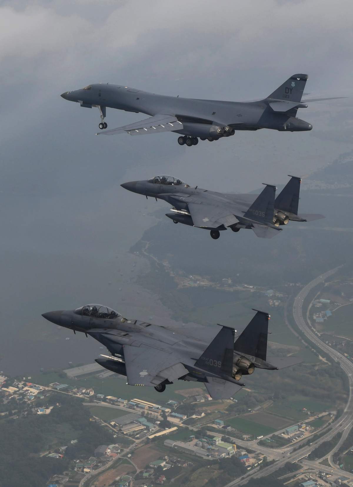 In this photo provided by South Korea Defense Ministry, a U.S. Air Force B-1B bomber, top, flies with South Korean fighter jets F-15K over Osan Air Base in Pyeongtaek, South Korea, Sunday, July 30, 2017.