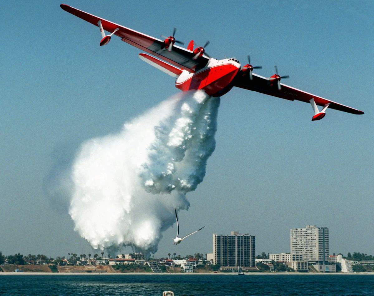 A Martin Mars flying boat water bomber makes a demonstration drop of some 7,200 gallons of water off the shore of Long Beach, Calif., in this Thursday, June 18, 1998 file photo. 