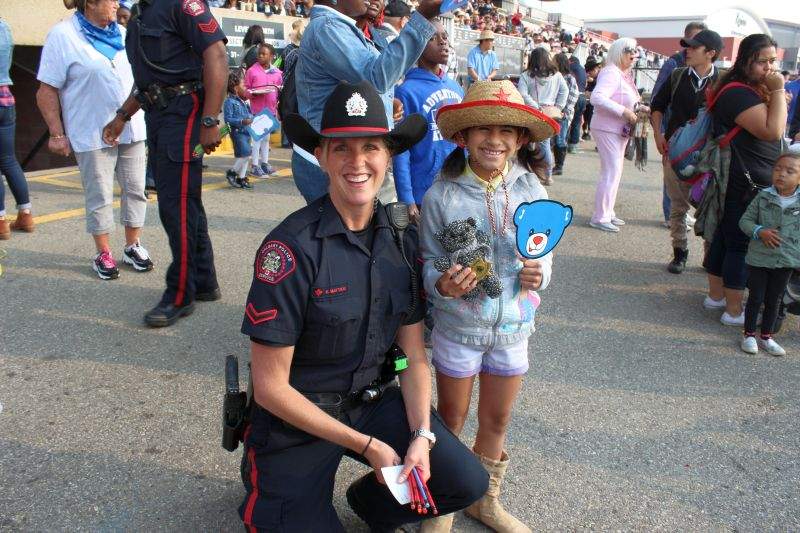 Ashlynn (right) and her teddy bear given to her by Officer Mattice (left) from the Calgary Police Service at the 2017 Calgary Stampede. 