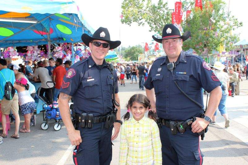 Ashlynn poses with two Calgary police officers at the 2017 Calgary Stampede, including officer Dunn (right).