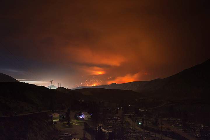 A wildfire burns on a mountain east of Cache Creek near a trailer park that was nearly destroyed by wildfire, in Boston Flats, B.C., July 10, 2017. 