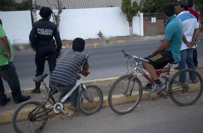 Bystanders look at bodies lying on a road in the town of Navolato, Sinaloa state, Mexico, June 29, 2017. 