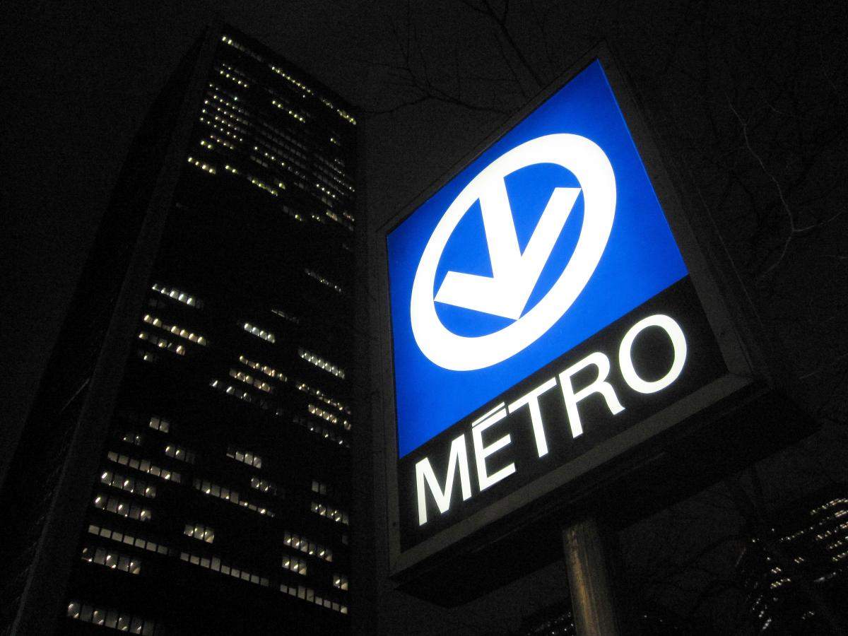 An outdoor metro sign in Montreal at night.