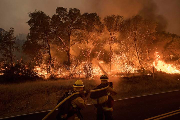 Firefighters work to contain a wildfire as it threatens to jump a road near Oroville, Calif., on Saturday, July 8, 2017.
