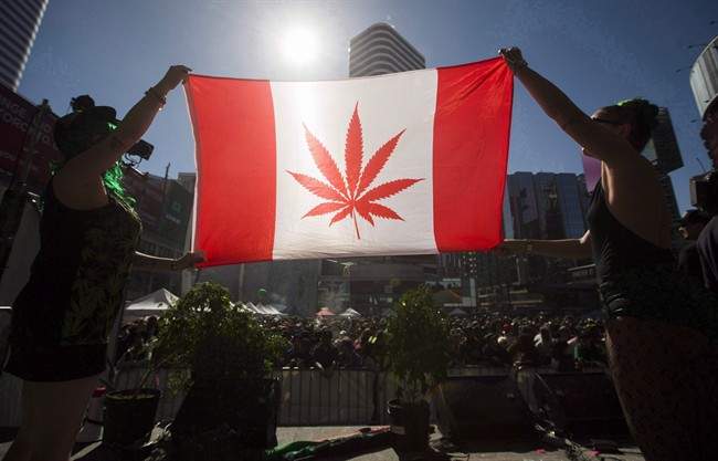 Two people hold a modified design of the Canadian flag with a marijuana leaf in in place of the maple leaf during the "420 Toronto" rally in Toronto, April 20, 2016. 