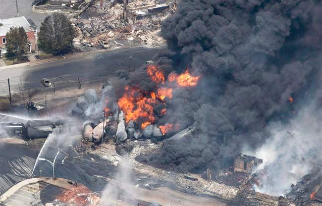 Smoke rises from railway cars that were carrying crude oil after derailing in downtown Lac-Megantic, Que., on July 6, 2013. The dangers of transporting hazardous goods by train were highlighted in tragic fashion four years ago, when an oil-laden runaway train derailed and crashed in the centre of Lac-Megantic, Que., killing 47 people.