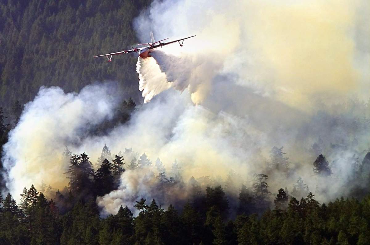 A Martin Mars water bomber attacks a fire in the Highlands, B.C. on Thursday July 31, 2003.