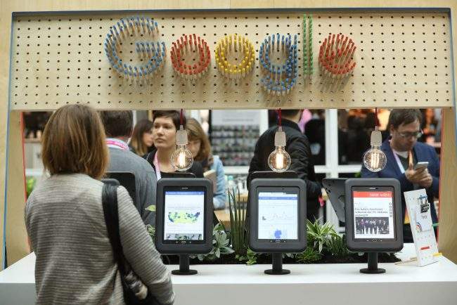 A visitor taps through news on a tablet at the Google Digital News Initiative stand at the Re:publica 17 conference on digital society in Berlin, Germany, May 8, 2017.