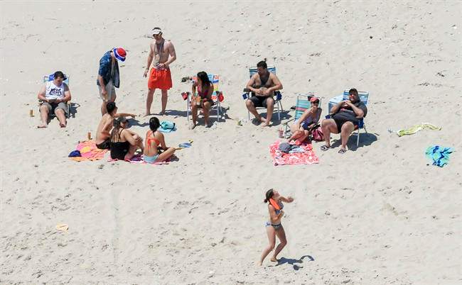 In this Sunday, July 2, 2017, photo, New Jersey Gov. Chris Christie, right, uses the beach with his family and friends at the governor’s summer house at Island Beach State Park in New Jersey.