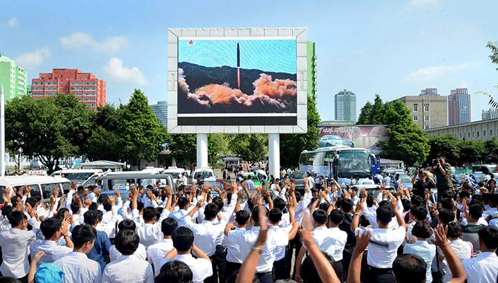 People watch a huge screen showing the test launch of intercontinental ballistic missile Hwasong-14 in this undated photo released by North Korea’s Korean Central News Agency, July 5, 2017.