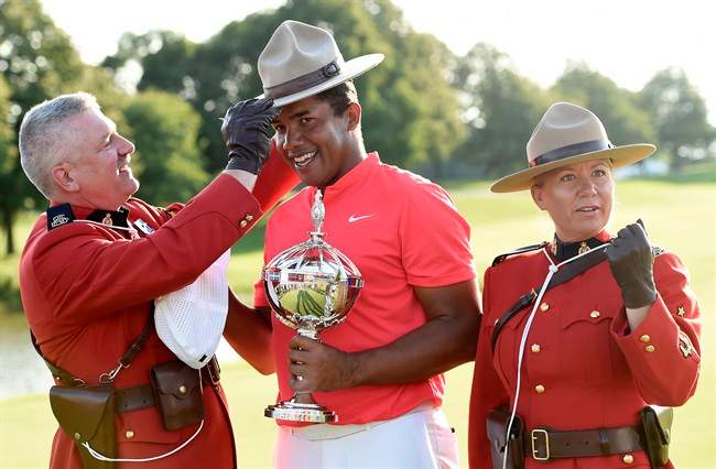 Jhonattan Vegas holds the winner's trophy as he tries on a Mountie stetson following his win at the final round of the 2017 Canadian Open at the Glen Abbey Golf Club in Oakville, Ont., on Sunday, July 30, 2017. 