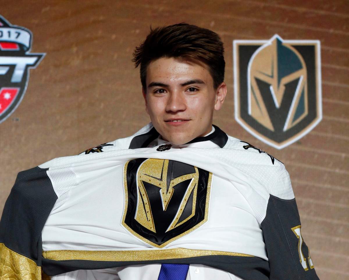 Nick Suzuki puts on a Vegas Golden Knights jersey after being selected by the team in the first round of the NHL hockey draft, Friday, June 23, 2017, in Chicago. (AP Photo/Nam Y. Huh).