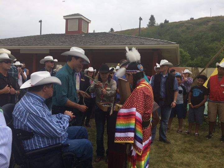 Prime Minister Justin Trudeau receives gifts from Lowa Beebe, chair of the Indian Events Committee at the Calgary Stampede.