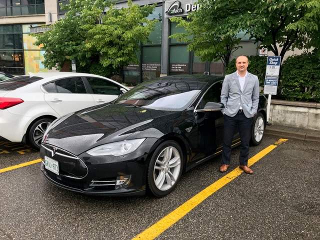 David Brown, 41, from Toronto, with his Tesla Model S, which he rents out through Turo.