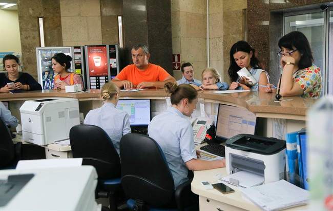 In this photo taken Wednesday, July 5, 2017, patients stand at the reception in a private clinic in Kiev, Ukraine. The clinic was one of many institutions disrupted by June 27 cyberattack which paralysed computers in Ukraine and across the globe. (AP Photo/Efrem Lukatsky).