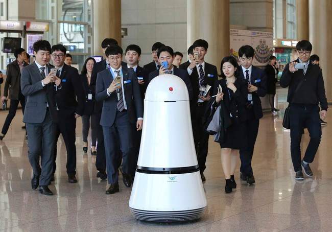 Employees of Incheon International Airport follow Troika, a self-driving robot made by LG Electronics, which moves around for visitors at the Incheon International Airport in Incheon, South Korea. Robots began roaming South Korea's largest airport last summer, helping travelers find their boarding gates and keeping its floors clean.