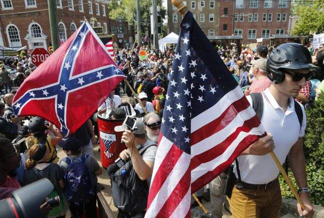 White nationalist demonstrators walk into Lee park surrounded by counter demonstrators in Charlottesville, Va., Saturday, Aug. 12, 2017. 


