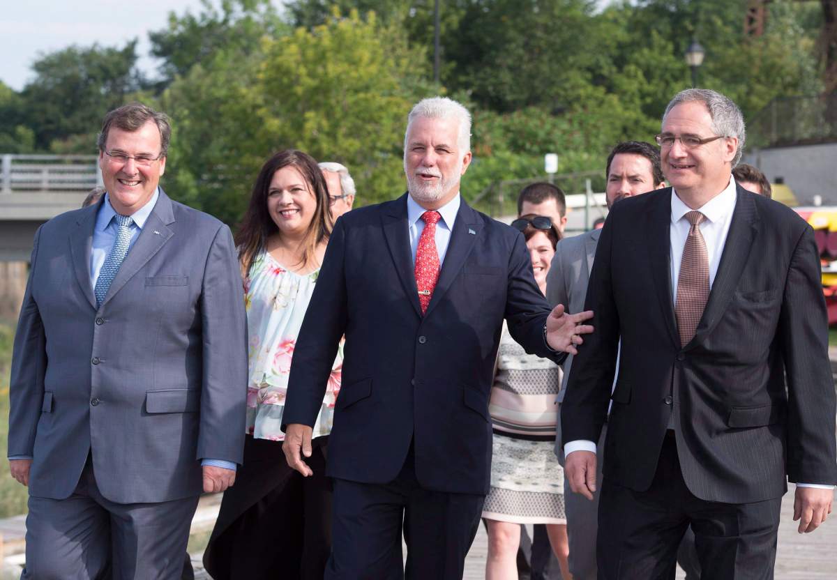 Quebec Premier Philippe Couillard, Quebec Employment and Social Solidarity Minister François Blais, left, and Eric Tetrault, candidate for a by-election in the Louis-Hébert riding, Tuesday, August 15, 2017 in Quebec City.