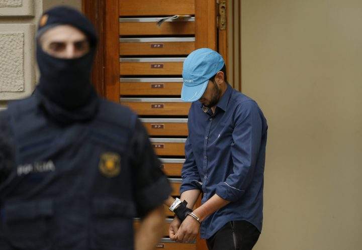 A suspect is led out of a building by police in Ripoll, north of Barcelona, Aug. 18, 2017.