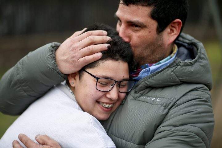 In this Aug. 15, 2017 photo, transgender boy Valentin, 16, is embraced by his father Juan Carlos at a park in Santiago, Chile.