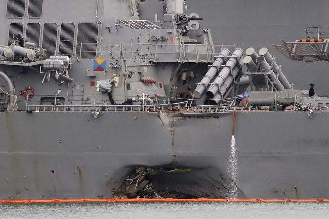 In this Aug. 22, 2017 file photo. the damaged port aft hull of the USS John S. McCain is visible while docked at Singapore's Changi naval base in Singapore.