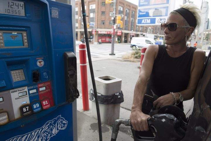 A woman fills up gas at a Toronto station on Aug. 31, days before a major gas prices hike is expected.