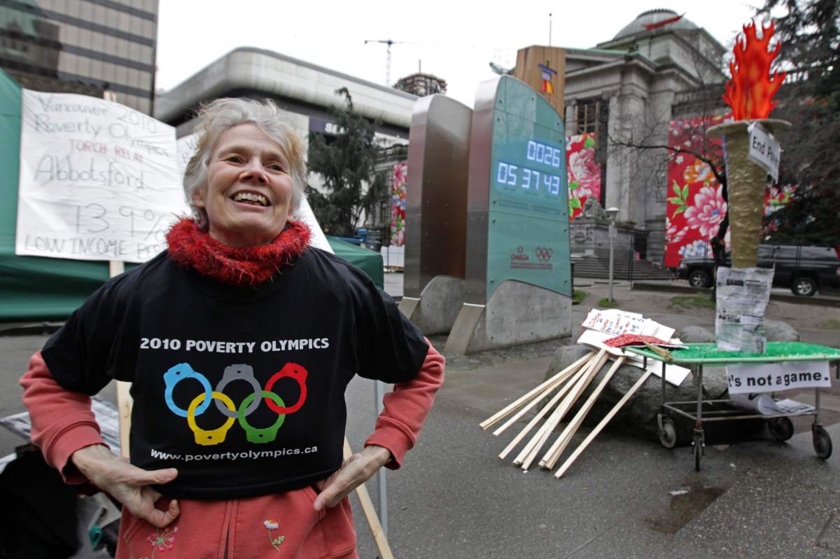 Jean Swanson puts on a t-shirt while preparing for a demonstration to announce the Poverty Olympics and torch relay near the Vancouver 2010 Winter Olympics countdown clock in Vancouver, B.C., on Sunday January 17, 2010.