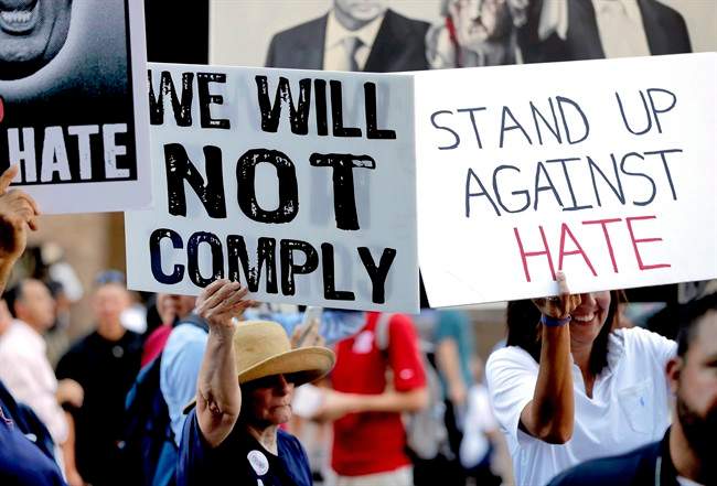 People protest outside the Phoenix Convention Center, Tuesday, Aug. 22, 2017, in Phoenix. Protests were held against President Donald Trump as planned to host a rally inside the convention center.