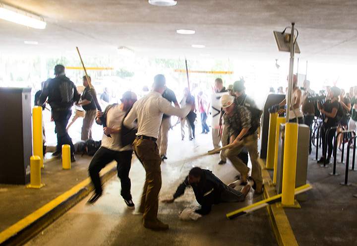 Several white supremacists attack a black man, bloodying him with wooden poles and part of a broken parking arm on August 12, 2017 in Charlottesville, Virginia.