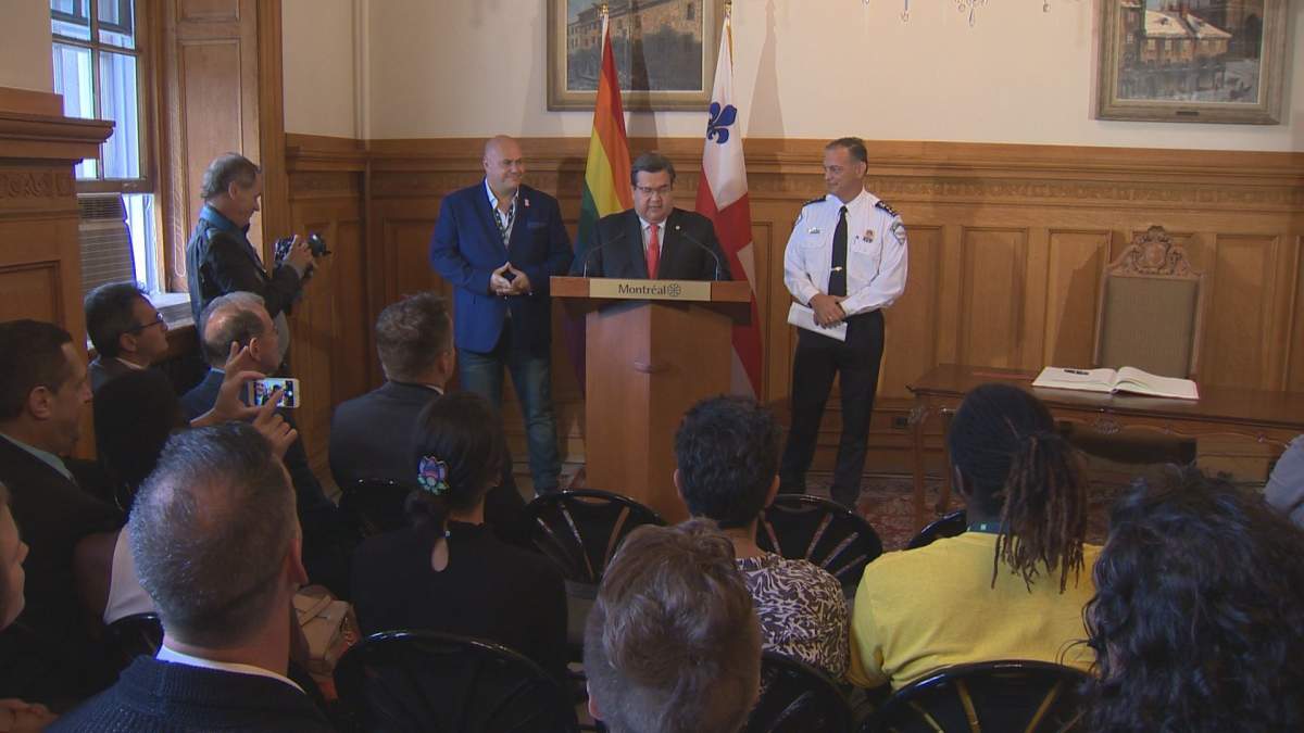 Montreal mayor Denis Coderre, alongside Montreal Pride's Éric Pineault and Chief of Montreal Police Philippe Pichet at city hall on August 18, 2017.
