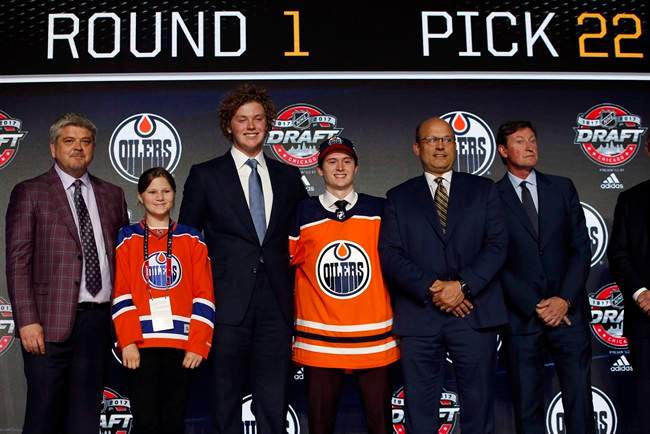 Kailer Yamamoto, center, wears an Edmonton Oilers jersey after being selected by the team during the first round of the NHL hockey draft in Chicago on June 23, 2017.